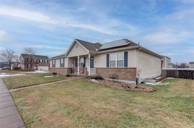 view of front of property featuring a front lawn, solar panels, and covered porch