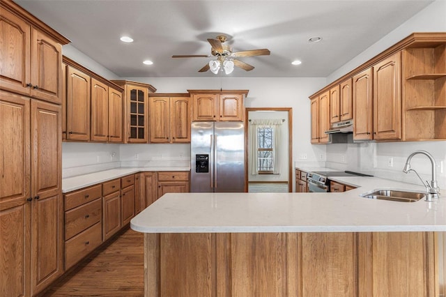 kitchen featuring sink, ceiling fan, appliances with stainless steel finishes, wood-type flooring, and kitchen peninsula