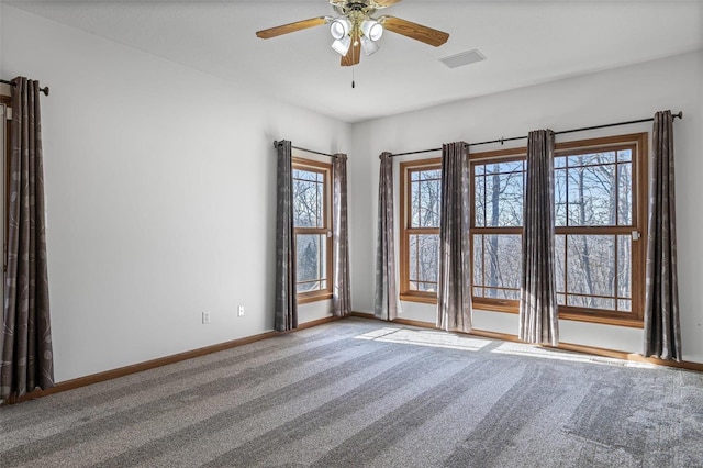 carpeted spare room featuring ceiling fan