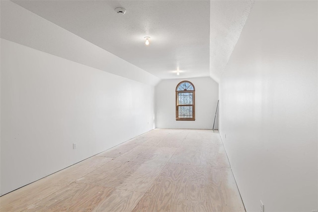 bonus room with vaulted ceiling and a textured ceiling