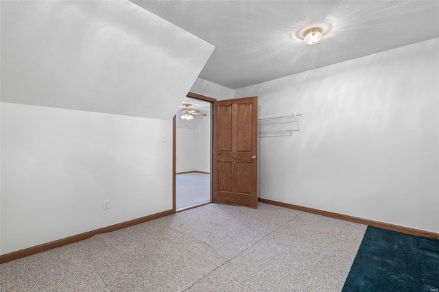 additional living space with lofted ceiling and a textured ceiling