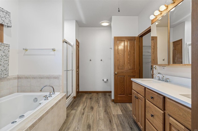 bathroom with wood-type flooring, separate shower and tub, and vanity