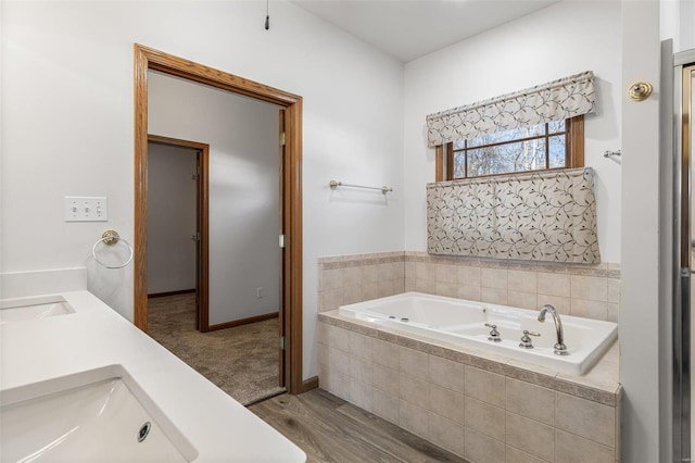 bathroom featuring vanity, hardwood / wood-style flooring, and tiled bath