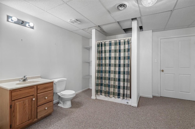 bathroom with vanity, toilet, a shower with shower curtain, and a drop ceiling