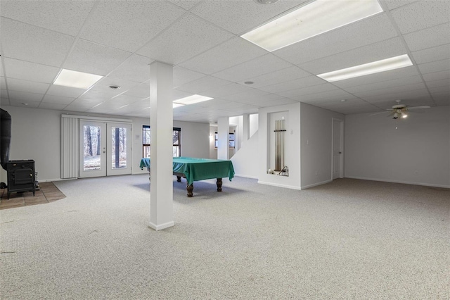 rec room featuring carpet, a drop ceiling, pool table, french doors, and a wood stove