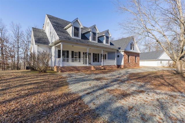 cape cod house featuring covered porch