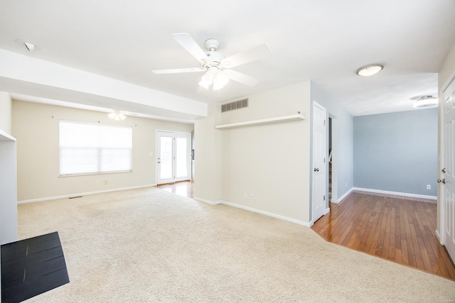 unfurnished living room with carpet, visible vents, and baseboards