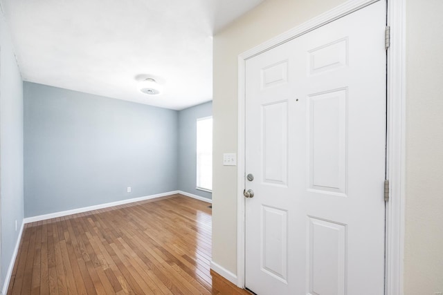 foyer entrance with hardwood / wood-style flooring and baseboards