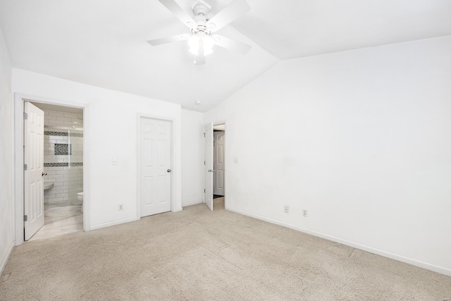 unfurnished bedroom featuring lofted ceiling, light carpet, ensuite bath, and baseboards