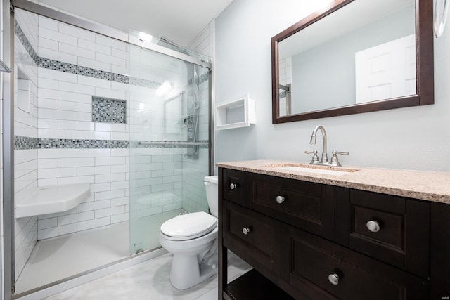 full bathroom with a stall shower, vanity, and toilet