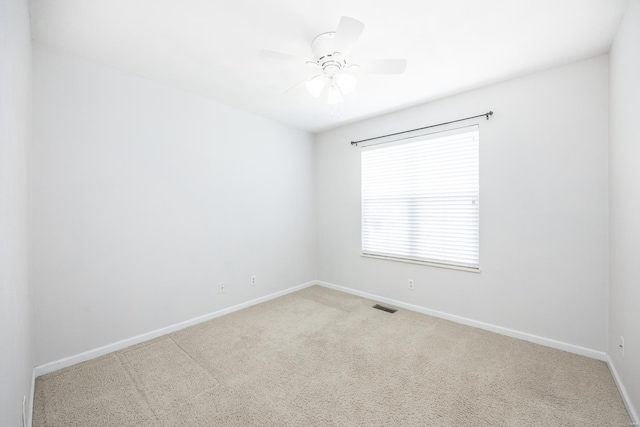 empty room featuring baseboards, carpet, visible vents, and a ceiling fan