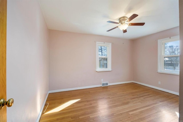 empty room with ceiling fan and light hardwood / wood-style flooring