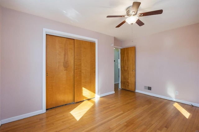 unfurnished bedroom with light hardwood / wood-style flooring, a closet, and ceiling fan