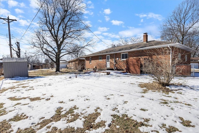 snow covered property featuring a shed