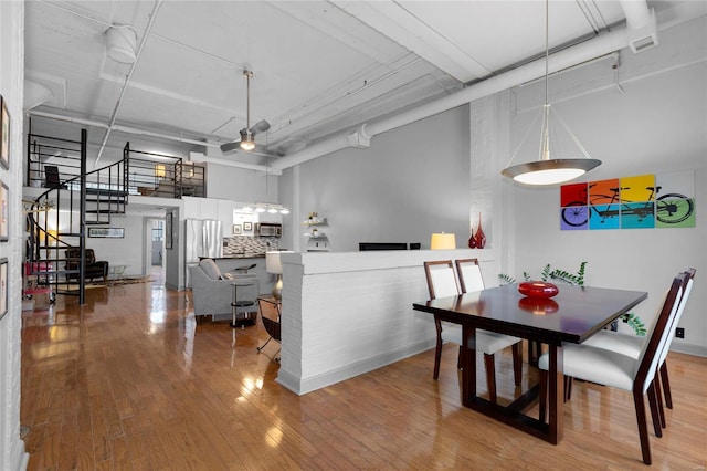 dining space featuring a towering ceiling, hardwood / wood-style floors, and ceiling fan