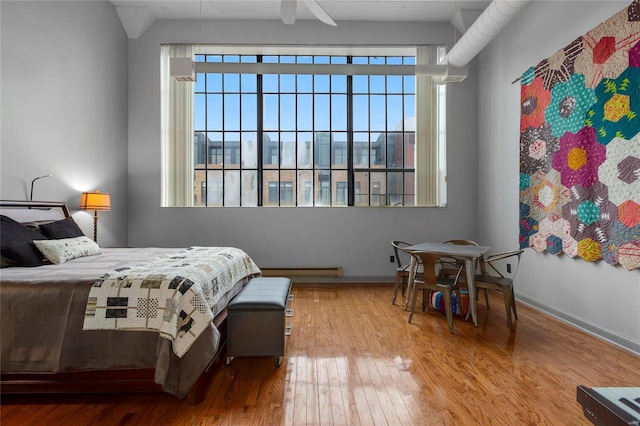 bedroom featuring wood-type flooring and baseboard heating