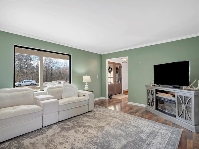 living room with hardwood / wood-style flooring, crown molding, and an inviting chandelier