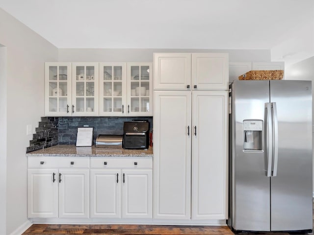 kitchen featuring white cabinetry, light stone countertops, stainless steel fridge with ice dispenser, and backsplash