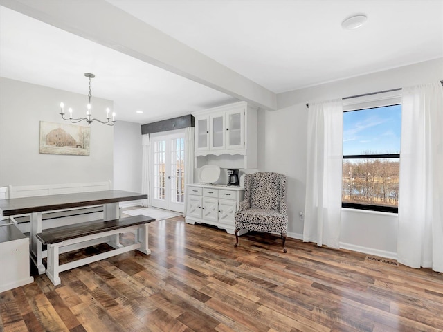 living area with french doors, dark hardwood / wood-style flooring, and a notable chandelier