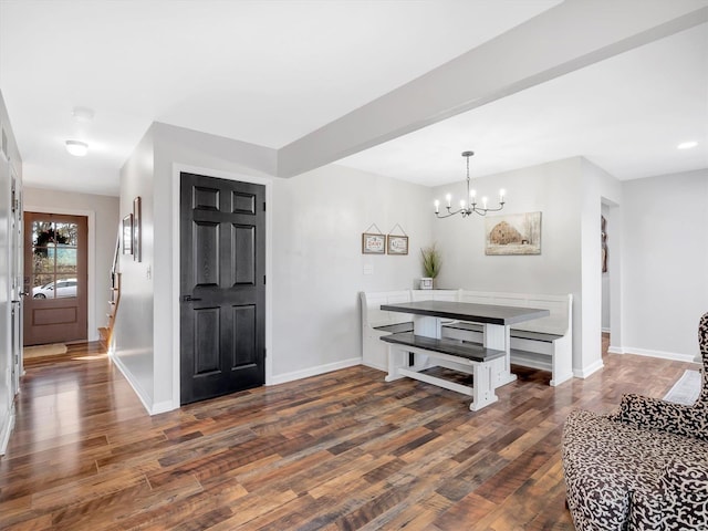 foyer featuring beamed ceiling, dark wood-type flooring, and a chandelier