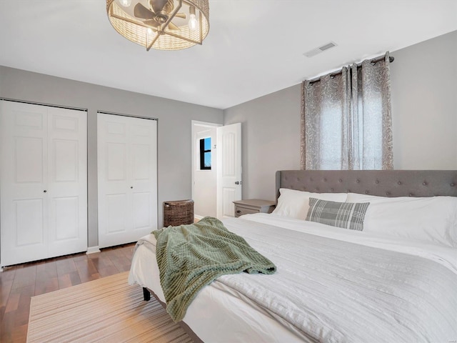 bedroom featuring hardwood / wood-style floors and two closets