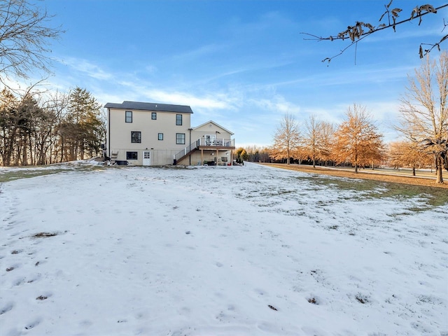 snow covered rear of property featuring a wooden deck