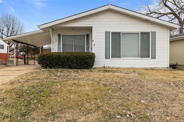 view of side of property featuring a yard and a carport