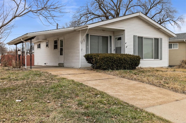 view of front of property featuring a carport and a front lawn