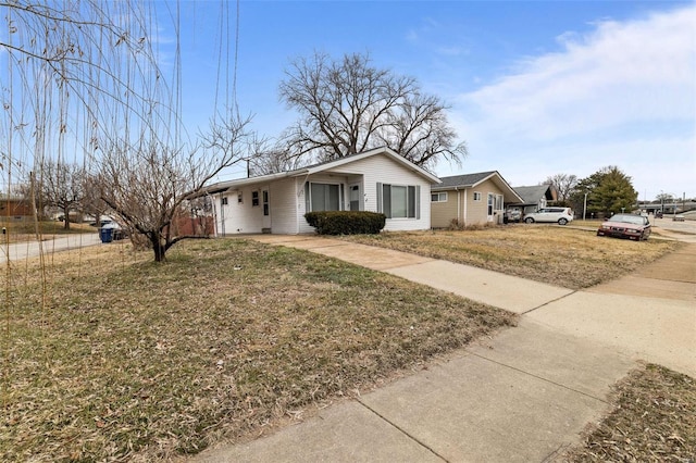 view of front of home with a carport and a front lawn