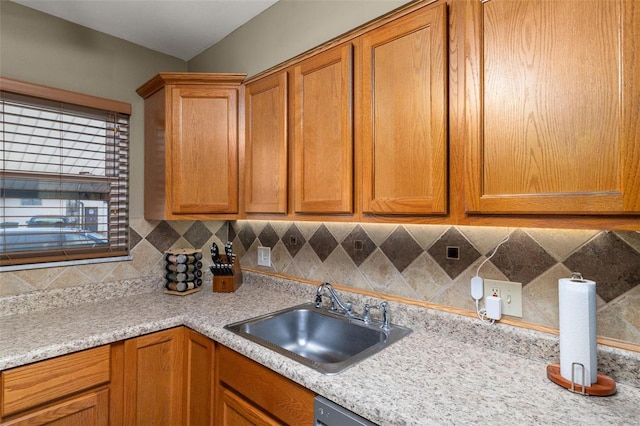 kitchen with light stone counters, sink, and decorative backsplash