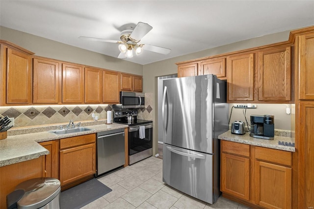 kitchen featuring sink, tasteful backsplash, light tile patterned floors, ceiling fan, and stainless steel appliances