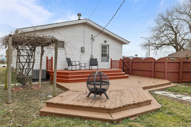 back of property with a fire pit, central AC, and a deck