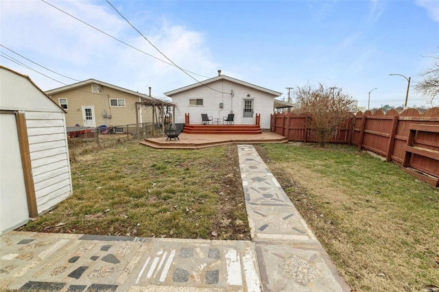 back of property with a shed, a lawn, and a deck