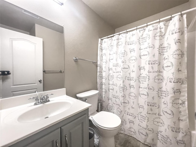 bathroom featuring vanity, walk in shower, and toilet