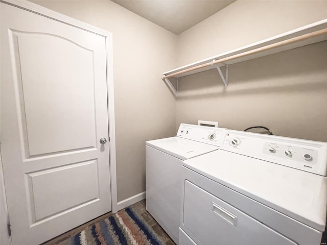 clothes washing area featuring dark hardwood / wood-style flooring and washer and clothes dryer