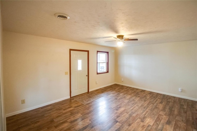 spare room with ceiling fan, a textured ceiling, and dark hardwood / wood-style flooring