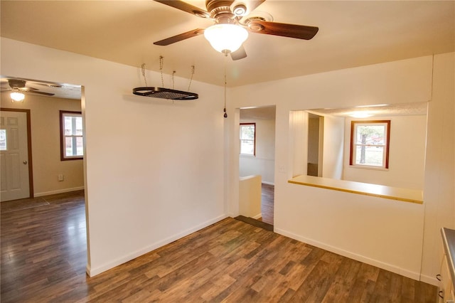 unfurnished room featuring ceiling fan, dark hardwood / wood-style floors, and a wealth of natural light