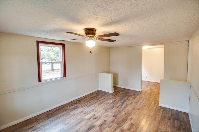 spare room with ceiling fan, hardwood / wood-style floors, and a textured ceiling