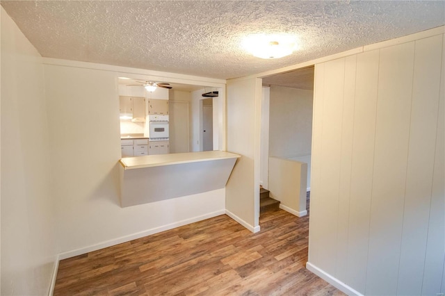 empty room with hardwood / wood-style flooring, ceiling fan, and a textured ceiling