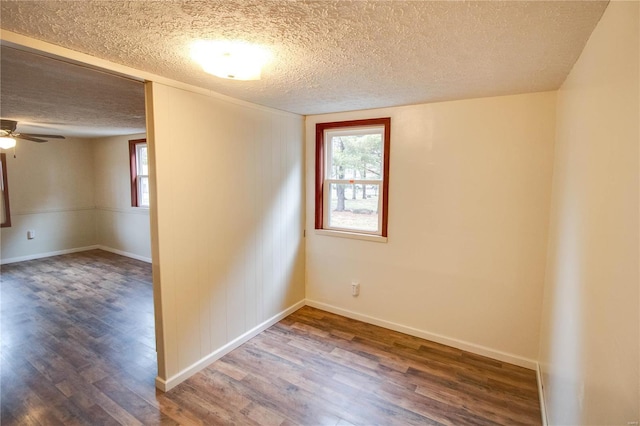 spare room featuring plenty of natural light, dark hardwood / wood-style floors, and a textured ceiling