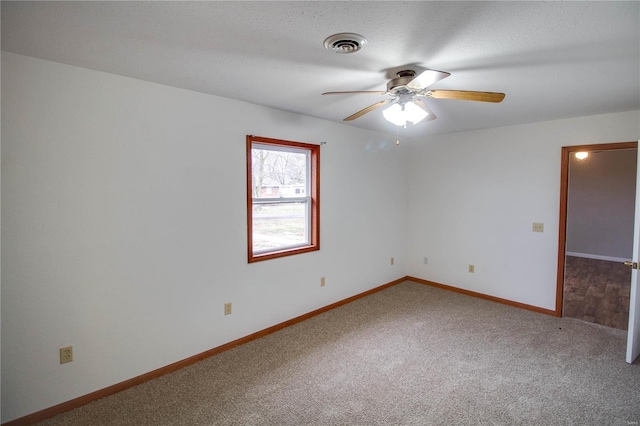 empty room with ceiling fan, carpet flooring, and a textured ceiling