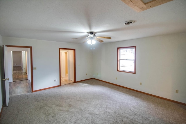 carpeted empty room featuring ceiling fan and a textured ceiling