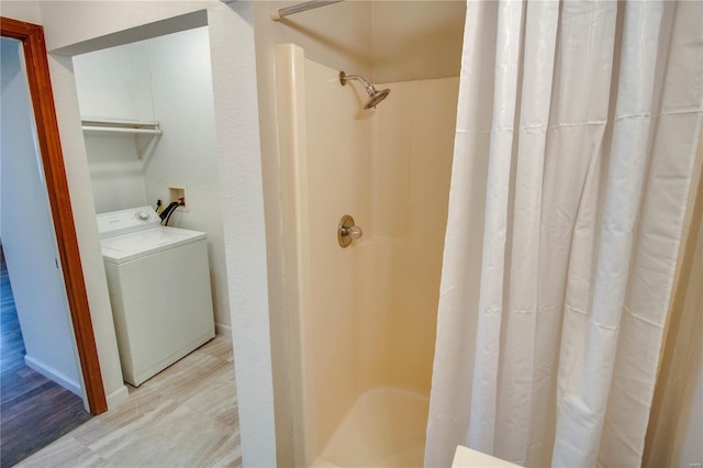 bathroom featuring walk in shower and washer / clothes dryer