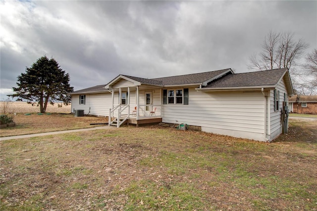 ranch-style house featuring cooling unit and a front yard