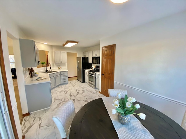 kitchen with gray cabinets, appliances with stainless steel finishes, and sink