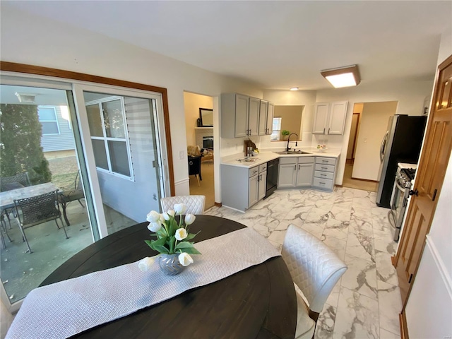 kitchen featuring sink, black dishwasher, gray cabinets, and stainless steel gas range