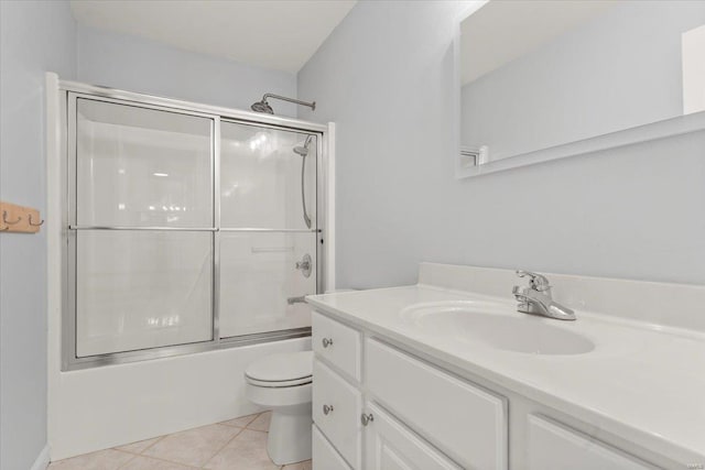 full bathroom featuring tile patterned flooring, vanity, bath / shower combo with glass door, and toilet