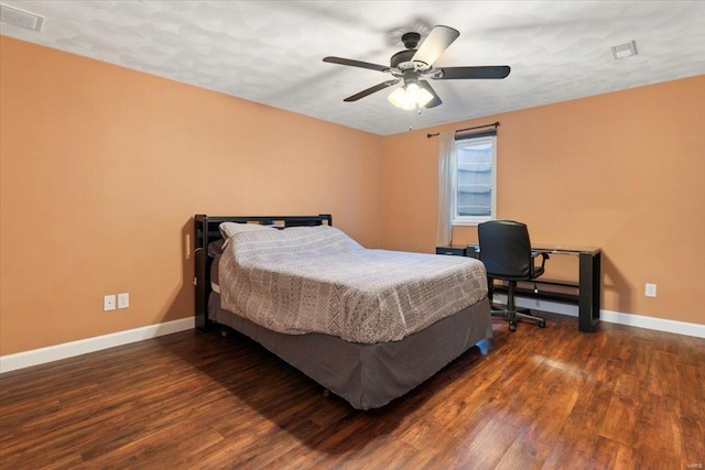 bedroom with a textured ceiling, dark hardwood / wood-style floors, and ceiling fan