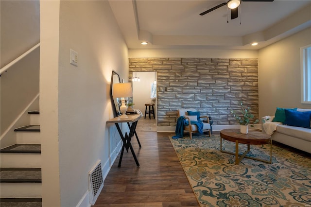 living room featuring ceiling fan and dark hardwood / wood-style floors