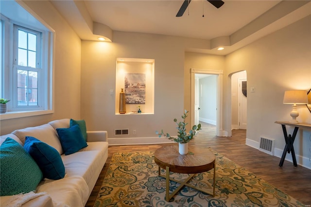 living room featuring ceiling fan and dark hardwood / wood-style floors